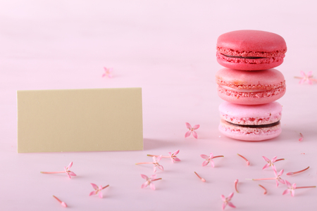stack of tasty colorful macarons with flowers and cardの写真素材