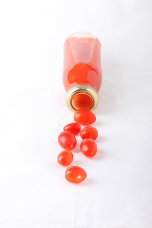 tomato juice bottle with fresh tomato , isolated on white backgroundの写真素材