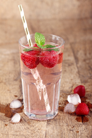 strawberry soda drinks and ice cube on wood table backgroundの写真素材