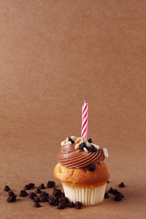 birthday cupcake with candle on chocolate backgroundの写真素材