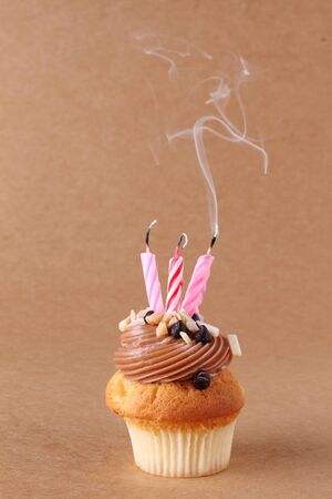 birthday cupcake with candles on plain backgroundの写真素材
