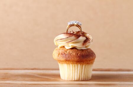 cupcake with diamond ring on wooden plateの写真素材