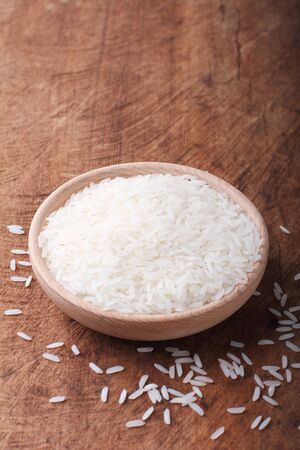 long grain rice,white jasmine,in a wooden bowl on wood backgroundの写真素材