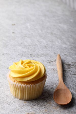 cupcake with swirl frosting with wooden spoonの写真素材