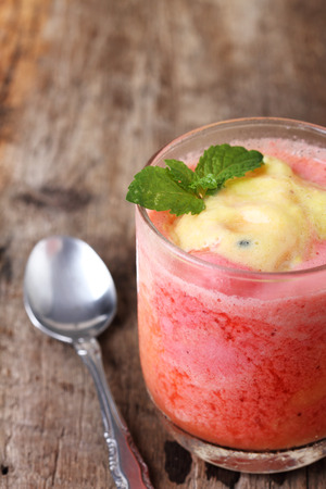 strawberry and passion fruit smoothie mix in a glass,wood table backgroundの写真素材