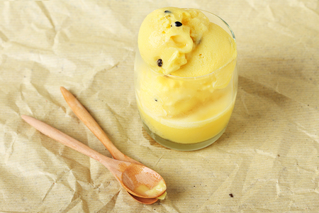 passion fruit sorbet in a glass with wooden spoonsの写真素材