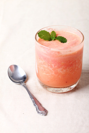 strawberry and passion fruit smoothie mix in a glass,with antique spoonの写真素材