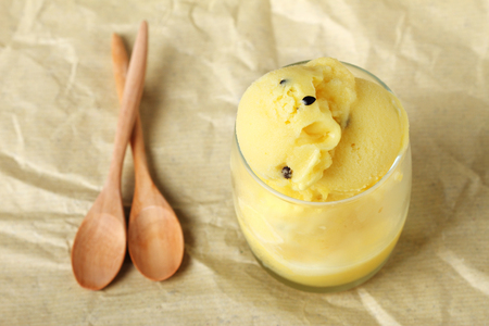 passion fruit sorbet in a glass with wooden spoonsの写真素材