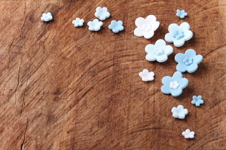 blue flowers, sugar icing candy on wood backgroundの写真素材