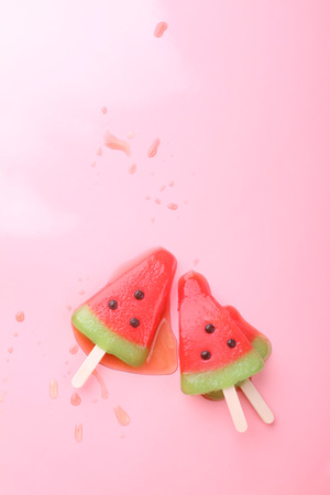 watermelon shaped ice cream pop lay on pink pastel backgroundの写真素材
