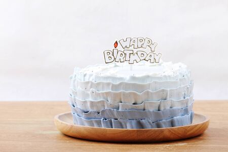 beautiful decorated cake with birthday label on wooden plateの写真素材