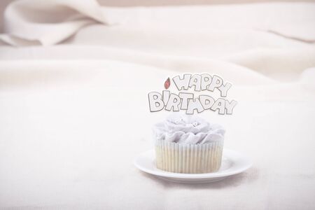 vanilla cupcake frosting with buttercream, flower shape, decorated with happy birthday labelの写真素材