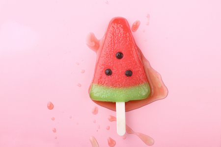 watermelon shaped ice cream pop lay on pink pastel backgroundの写真素材