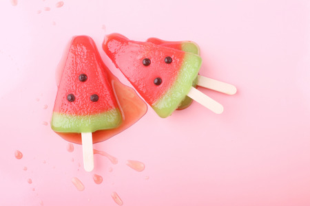 watermelon shaped ice cream pop lay on pink pastel backgroundの写真素材