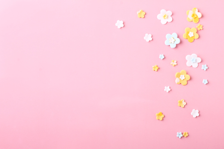 white and yellow flowers, sugar icing candy on pink backgroundの写真素材