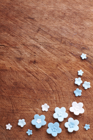 blue flowers, sugar icing candy on wood backgroundの写真素材