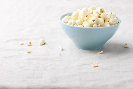 caramel popcorn in bowl on table with napkinの写真素材