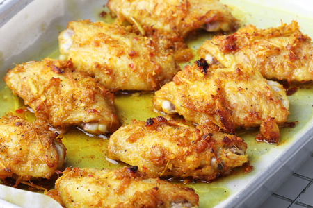 chicken wings roasted with turmeric and herbs in baking trayの写真素材