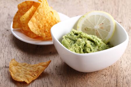 guacamole with corn chips on wooden tableの写真素材
