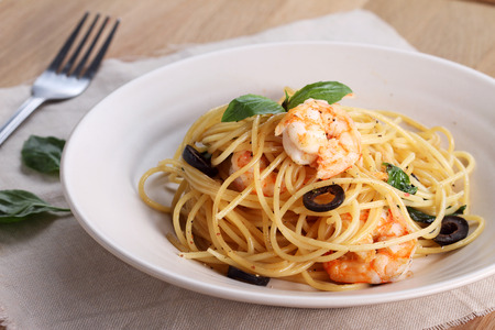 spaghetti pasta with shrimps and sweet basil on wooden tableの写真素材