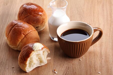 torn buns with coffee and milk for breakfast