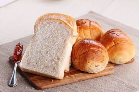 Sliced white bread and buns with jamの写真素材