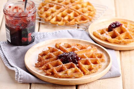waffles cinnamon sugar top with raspberry jelly on wooden backgroundの写真素材