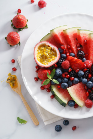 healthy fresh mixed fruit salad on white plate, flat layの写真素材