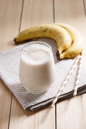 Banana smoothie on wooden backgroundの写真素材