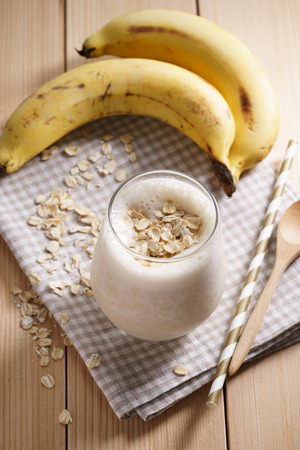 Banana smoothie with oat on wooden backgroundの写真素材