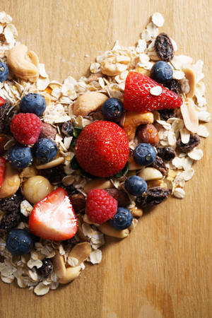 granola healthy snack with fresh berry in heart shapedの写真素材