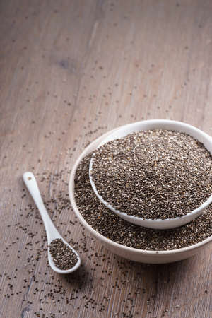 Healthy Chia seeds in bowl on wooden tableの写真素材