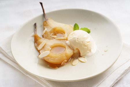 sweet poached pear cut half with vanilla ice creamの写真素材