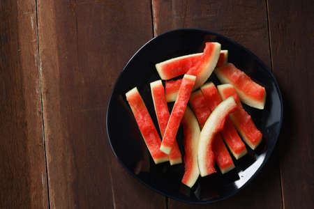 watermelon rind cut in piece on black plateの写真素材