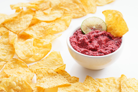 beet hummus in bowl on white background