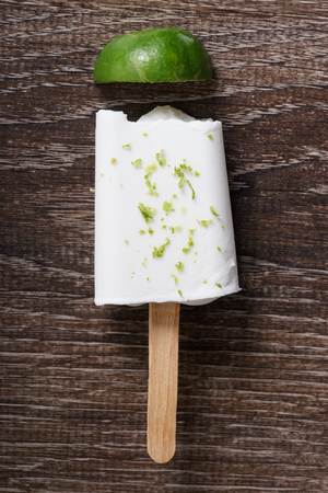 coconut ice pops ,coconut ice cream bar, with fresh green lime zest on wooden backgroundの写真素材