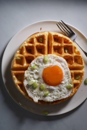 elgian waffle top with fried egg for breakfast ,hard lightの写真素材