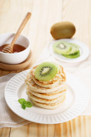 pile of pancakes with honey syrup and fresh kiwi slicedの写真素材
