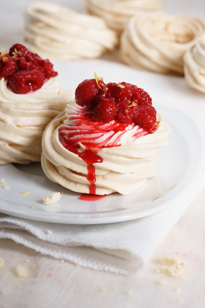 meringue nests topped with cream and raspberry candy sauceの写真素材