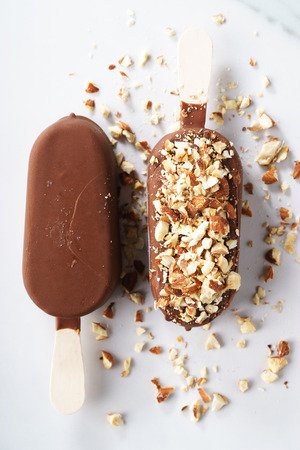 vanilla popsicles coat with chocolate and top with almond.の写真素材