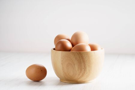 brown chicken eggs in wooden bowlの写真素材