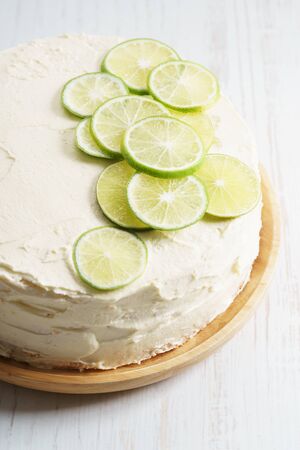 sweet white buttercream round cake with sliced lime on topの写真素材