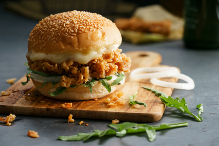Tasty fired chicken with arugula and mayonnaise sauce served on wooden boardの写真素材
