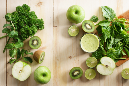 healthy green smoothie made with organic green fruits and vegetables in glassの写真素材
