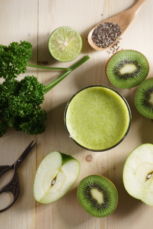 healthy green smoothie made with organic green fruits and vegetables in glassの写真素材