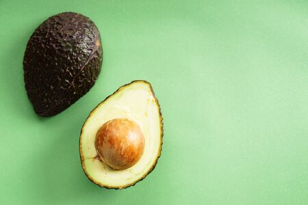avocado on green background,cut half