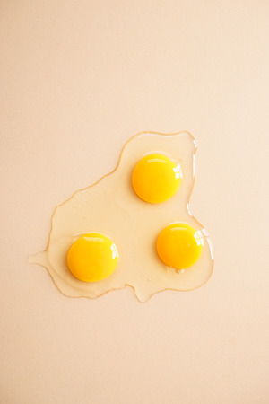 fresh egg yolks and albumen on color backgroundの写真素材