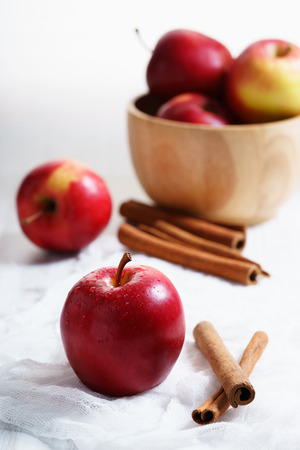 ripe red apple with cinnamon on tableの写真素材