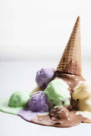 various color ice cream scoops and waffle cone drop on white backgroundの写真素材