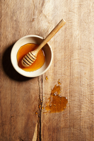 honey dipper and honey in wooden cup on wooden background
の写真素材